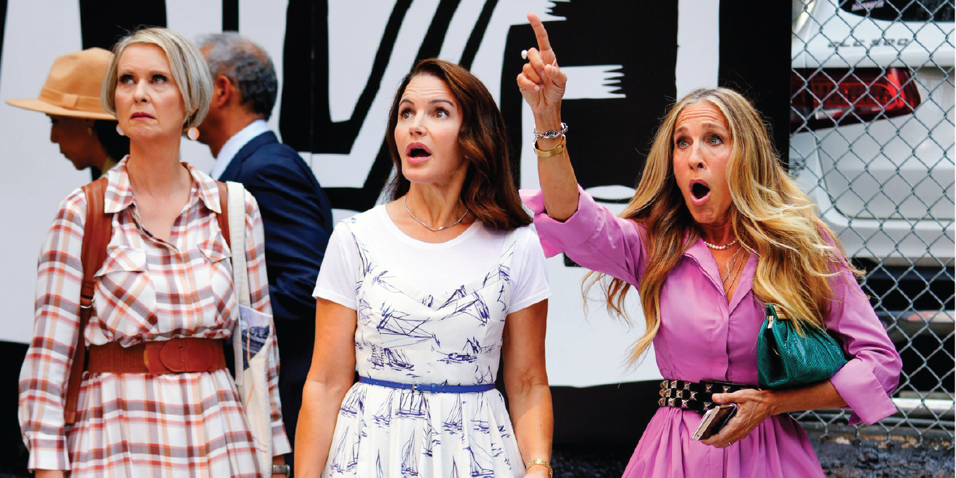 Miranda, Charlotte, and Carrie from Sex and The City surprised by something in the distance.