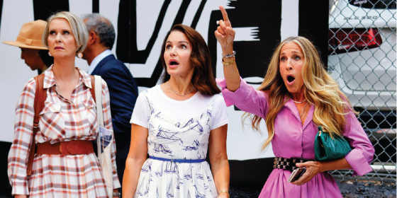 Miranda, Charlotte, and Carrie from Sex and The City surprised by something in the distance.