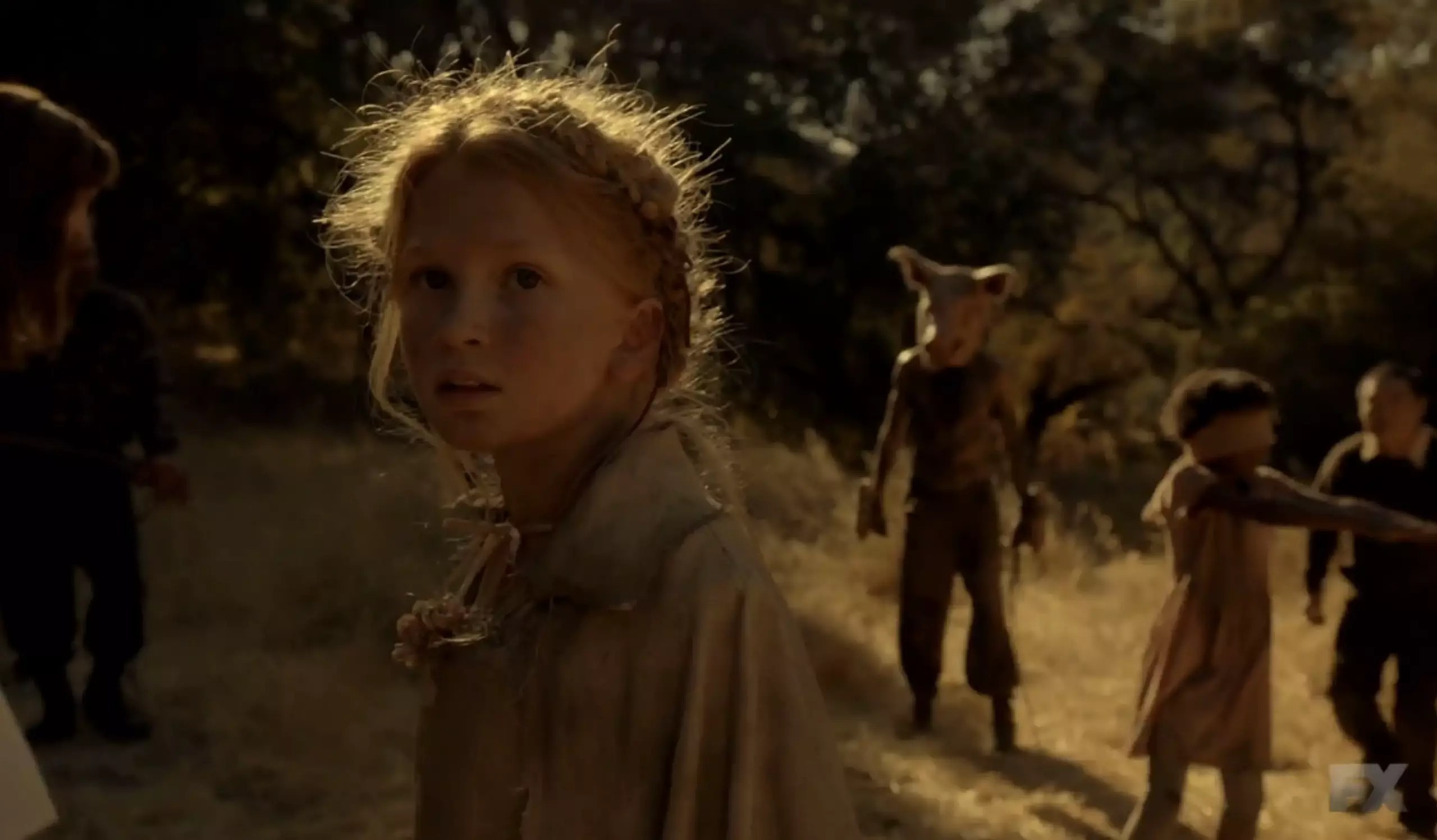 Flora staring at the camera with the Pig Man right behind her on American Horror Story: Roanoke